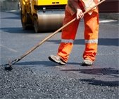 worker repaving road