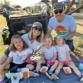 family sitting in the grass eating