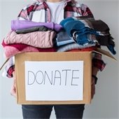 someone holding a box of clothes that says "donations"
