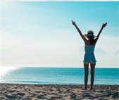 woman standing with arms outstretched on hill