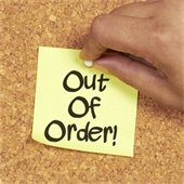 yellow out of order sticky note on a cork board